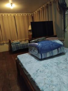 a bedroom with a large bed and a television at casa da meg in Tiradentes