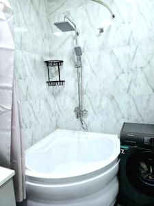 a bathroom with a white toilet and a shower at Golden house deluxe 2 in Bukhara