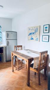 a dining room table with two chairs and a refrigerator at Casa Milos in Santa Rosa de Calamuchita