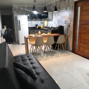 a living room with a couch and a kitchen at FLAT a 2min do relogio da flores com ar condicionado in Garanhuns +24 photos