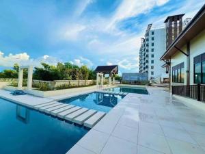 a swimming pool with blue water and a building at Tropical Hideaway with Pool 1BR Panglao in Dauis