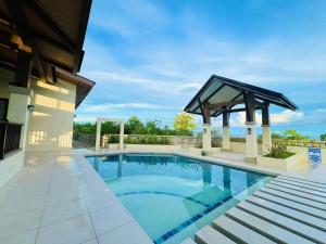 a swimming pool with a gazebo next to a building at Tropical Hideaway with Pool 1BR Panglao in Dauis +6 photos