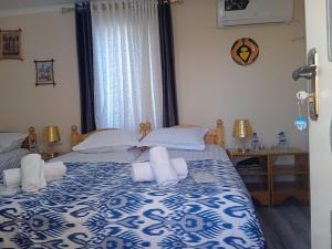 una camera con due letti con lenzuola bianche e blu di Guest House AN With Free Out of City Tour a Bukhara
