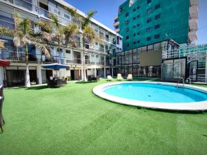 un ampio cortile con piscina in un edificio di Hotel Divasto a Iquique