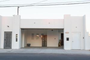 un edificio blanco con dos puertas y una calle en Good Life Casita at Rocky Point, en Puerto Peñasco
