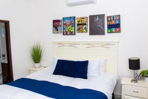 Un dormitorio con una cama blanca y algunas fotos en la pared en Good Life Casita at Rocky Point, en Puerto Peñasco