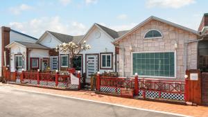una casa con una valla roja delante de ella en Sokcho Seohyeon Ine Pension, en Sokcho 1 foto más
