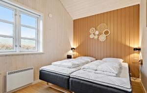 a bedroom with two beds and a window at Holiday Home Barsbæklund Xi in Loddenhøj
