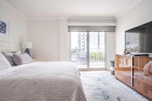 a white bedroom with a large bed and a large window at The Blue Octopus - 1br King Bed Condo in Fort Lauderdale +33 photos