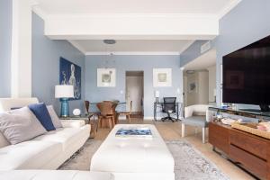 a living room with a white couch and a tv at The Blue Octopus - 1br King Bed Condo in Fort Lauderdale