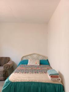 埃斯孔迪多港Casa Tobe的一张位于带椅子的房间的床