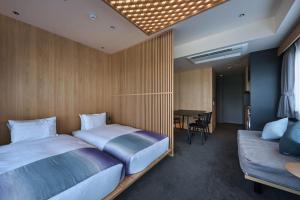 a bedroom with a bed and a couch and a table at Minn Nijo-jo in Kyoto
