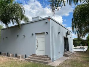 ein weißes Gebäude mit einer weißen Tür und Treppe in der Unterkunft Casa en Yanda, sobre Ruta Nacional 9, salida directa Autódromo in Zanjón