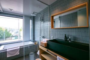 a bathroom with a green sink and a mirror at Minn Nijo-jo in Kyoto
