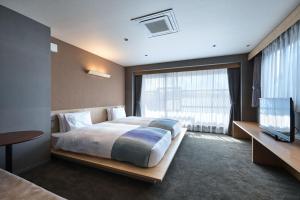 a bedroom with a large bed and a television at Minn Nijo-jo in Kyoto