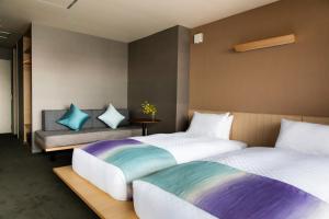 a bedroom with two beds and a bench at Minn Nijo-jo in Kyoto