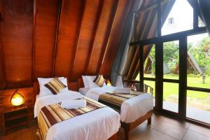 trois lits dans une chambre avec une grande fenêtre dans l'établissement Dewantara Boutique Villa Resort Bali, à Umeanyar 71 autres photos