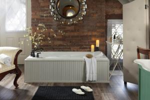 a bathroom with a bath tub and a brick wall at Inn at Woodhaven-In the Heart of the Bourbon Trail-Over 12 Distilleries Nearby in Louisville +75 photos