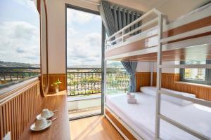 una camera con letto a castello e balcone di Lotus Hotel Đà Lạt a Khu Chi Lăng
