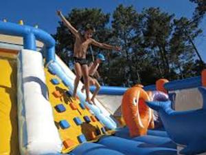 two boys on a water slide at a water park at Maison confortable 6 pers, terrasse, résidence avec piscine et parking proche mer - FR-1-239-1118 in Ondres