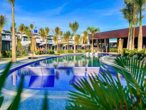 a pool at the resort with chairs and palm trees at Olee SeaView Resort in Mui Ne