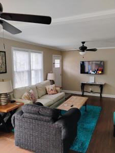 ein Wohnzimmer mit Couch und Tisch in der Unterkunft Charming, Cozy Cottage Near Downtown New Bern in New Bern