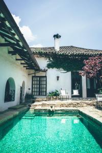 a swimming pool in front of a house at Hotel Hacienda Baza in Tibaná