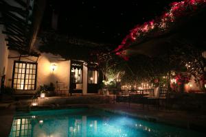 a swimming pool in front of a house at night at Hotel Hacienda Baza in Tibaná