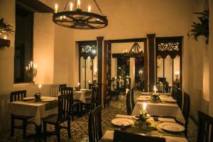 a dining room with tables and chairs and a chandelier at Hotel Hacienda Baza in Tibaná