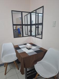 a table and two chairs in a room with a mirror at The Grand Towers Manila in Manila