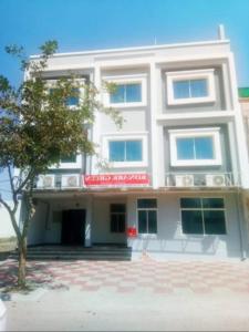 - un bâtiment blanc avec un panneau rouge dans l'établissement hotel konark green, à Bhopal