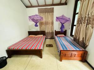 two beds in the corner of a room at Freedom Hotel Galgamuwa in Galgamuwa