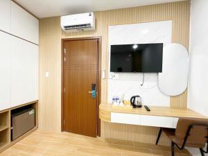 ホーチミン・シティにあるK&T Hotel Sân Bay TSN-150m từ Nhà Ga T3のデスク、壁掛けテレビが備わる客室です。