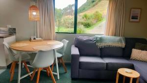 a living room with a table and a couch at Pukemara Retreat in Pukehiki