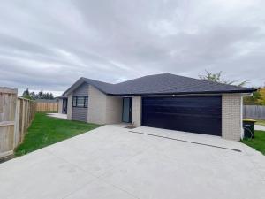 eine freistehende Garage mit großer Auffahrt in der Unterkunft Rotorua Sunshine Brand New 4 Bedroom house in Rotorua