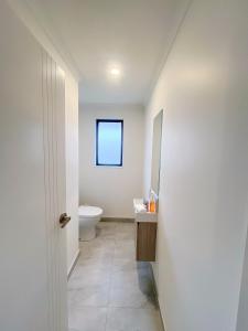 ein Badezimmer mit Toilette und Waschbecken in der Unterkunft Rotorua Sunshine Brand New 4 Bedroom house in Rotorua + 24 Fotos