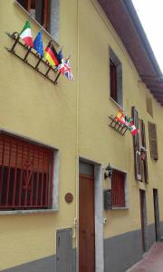 un edificio amarillo con banderas a un lado en Cadorna Chalet, en Veleso