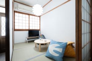 a living room with a couch and a table at LN25三宮徒歩8分の2DKハウスSwallowMaisonet in Kobe