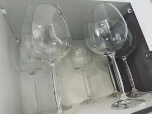 a group of wine glasses sitting on a shelf at Apartamento Duplex em Mafra SC in Mafra