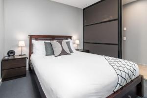 Un dormitorio con una cama grande con sábanas y almohadas blancas. en Stunning 1BR Apartment with Water Views, en Kingston 