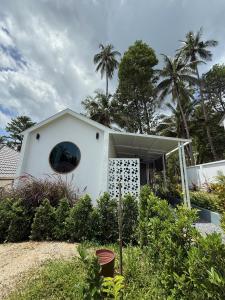 ein weißes Haus mit einem runden Fenster und Palmen in der Unterkunft High-In Holiday Home&Villa in Ko Phangan + 36 Fotos