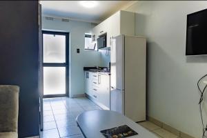 a small kitchen with a refrigerator and a table at Grace Villas 7 in East London