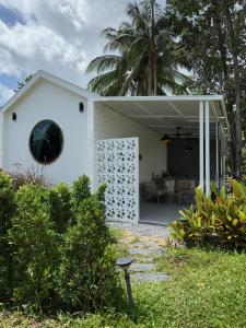 ein weißes Haus mit einem großen Fenster auf der Seite in der Unterkunft High-In Holiday Home&Villa in Ko Phangan