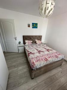 ein Schlafzimmer mit einem Bett und einem Kronleuchter in der Unterkunft CMD Apartament 2 camere in Buzău