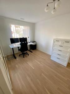 an office with a desk and a computer in a room at Moderne Wohnung mit Einrichtung in Muttenz