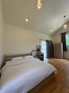 a bedroom with a large white bed and a desk at High-In Holiday Home&Villa in Ko Phangan