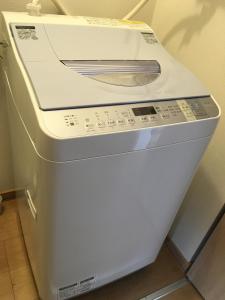 a white washing machine sitting next to a wall at Wonderland Furano Pine in Furano