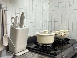 a kitchen with a stove with a pot and scissors at OnMeSTAY in Suwon