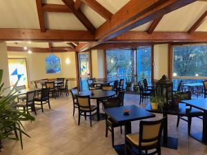 a restaurant with tables and chairs and windows at Brit Hotel Confort Deltour Mende in Mende