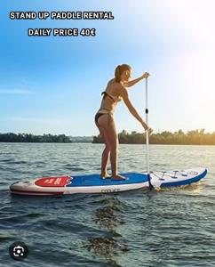 a woman in a bikini standing on a paddle board at Lucy's guesthouse in La Digue